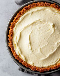 an overhead view of a pie with white frosting on top, in a pan