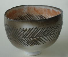 a black and white bowl with feathers on it