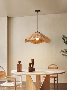 a dining room table with chairs and a lamp hanging from it's ceiling over it