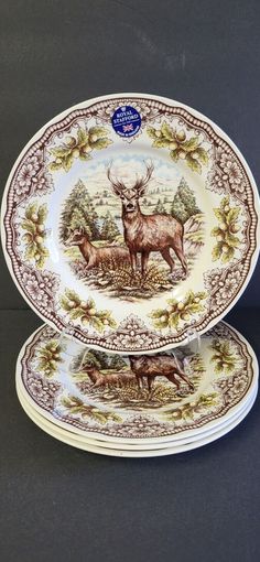 two plates with deer on them sitting next to each other in front of a black background