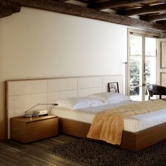 a large bed sitting inside of a bedroom on top of a hard wood floor