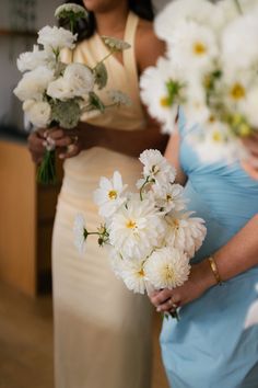 two bridesmaids holding bouquets of white flowers