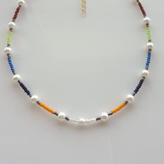 Add a pop of color to your summer wardrobe with this stunning and vibrant colorful seed bead boho necklace. Handcrafted with care, this pearl beaded necklace is the perfect accessory for a casual day at the beach or a fun night out. The rainbow beads add a playful touch, making it a versatile piece for any occasion. This beaded choker necklace also makes a thoughtful gift for her or him, adding a touch of bohemian flair to their jewelry collection. Make a statement with this unique and stylish b Colorful Beads For Jewelry Making In Summer, Bohemian Beaded Necklaces With Spacer Beads For Vacation, Multicolor Beads For Summer Jewelry Making, Bohemian Beaded Necklace For Vacation, Bohemian Summer Letter Beads, Colorful Beaded Chain Beads For Beach, Colorful Beaded Chain For Beach, Bohemian Beaded Necklaces With Letter Beads, Bohemian Beaded Necklace With Letter Beads