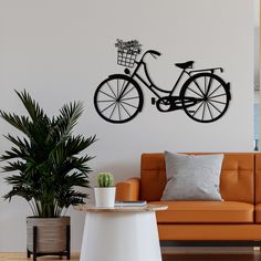 a living room with a couch, coffee table and bike wall decal on the wall