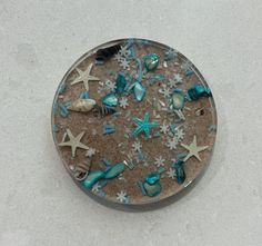 a glass plate with sea shells and starfishs on the bottom, sitting on a white surface