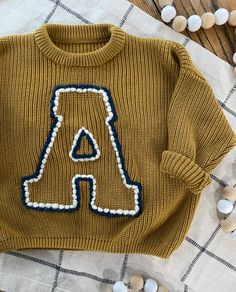 a knitted sweater with the letter a on it