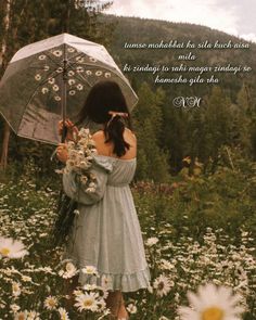 a woman holding an umbrella standing in a field full of daisies and wildflowers