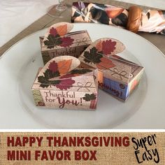 three thanksgiving boxes on a plate with the words happy thanksgiving written on them and an image of fall leaves