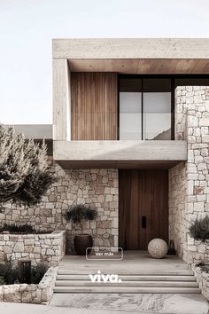 a house with stone walls and steps leading up to the front door is shown in black and white