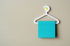 a blue piece of paper hanging from a white hanger with a light on it