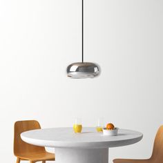 a white table with two chairs and a light hanging from it's center point