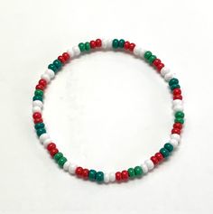 This bracelet is made with red, Emerald green, medium green and white size 6/0 (4mm) seed beads and is strung on high quality stretch cord. SIZE OPTIONS: - Small: 6.5 inches - Average: 7 inches - Medium/Large: 7.5 inches - Large: 8 inches - Extra Large: 8.5 inches CUSTOM: - I'm happy to create custom products. If you would like something different, please contact me. PROCESSING TIME: - Your bracelet will ship in 1-3 business days after purchase. CANADIAN ORDERS:  - FREE SHIPPING TO CANADA. Sent Red And Green Bracelet, White Bracelets With Colorful Beads For Christmas, Festive Green Beaded Bracelets With Colorful Beads, White Christmas Bracelets With Colorful Beads, Festive Green Beaded Bracelets, Christmas White Bracelets With Colorful Beads, Multicolor Beaded Bracelets With Round Beads For Holiday, White Beaded Bracelets With Letter Beads For Christmas, White Round Bead Bracelets For Holiday