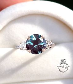 a blue diamond ring sitting on top of a white cloth