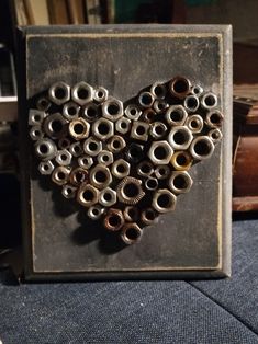 a heart made out of nuts on top of a wooden box