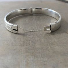 "A beautifully engraved scrollwork graces this bangle on the front; the back is without decoration. The bracelet, made in Chester, England in 1960, is fully hallmarked on the interior with the English standard for sterling. The lovely piece opens with and closes with a click, it has a safety chain for added security. Bracelet (closed): approx. 2 1/4 x 2 1/16\" width 7/16\" (14m) interior perimeter 6 3/4\" BB005 ✦All of our vintage bracelets ship with complimentary insurance✦ ✤Our entire selectio Classic Engraved Bangle For Ceremonial Occasions, Classic Ceremonial Engraved Bangle, Heirloom Etched Bangle Cuff Bracelet, Classic Engraved Cuff Bracelet For Ceremonial Occasions, Elegant Stamped Cuff Bracelet In Bangle Style, Elegant Stamped Cuff Bracelet Bangle, Formal Engraved Bangle Cuff Bracelet, Classic Engraved Ceremonial Cuff Bracelet, Classic Engraved Sterling Silver Bangle Bracelet