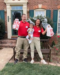 a man and woman are holding two bags while sitting on a bench in front of a brick building