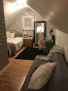 an attic bedroom with two beds and a couch