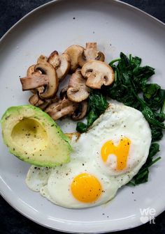 an egg, spinach and mushrooms on a plate