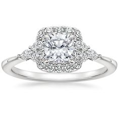 a white gold engagement ring with an oval center surrounded by round brilliant cut diamond halos