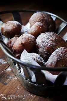 powdered sugar covered donuts in a glass bowl