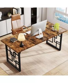 a computer desk with a laptop on top of it in a living room next to a window