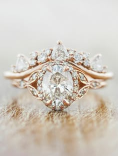 an engagement ring with a pear shaped diamond surrounded by smaller pear shaped diamonds on top