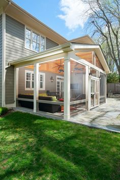 a backyard with a covered patio and outdoor living area in the back yard, surrounded by green grass