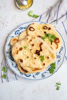 three pita breads on a blue and white plate