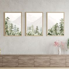 three paintings hanging on the wall above a dresser with flowers and vases in front of it