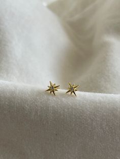 * Metal Material: S999 with 18K Gold Plated - S925 Backing * Stone: Zircon  * Dimensions: 6.34mm X 6.10mm * Color: Gold * Sold as a pair (2 pieces) The North Star means direction, guidance, stability and purpose. May these earrings inspire you to keep working on your goals no matter how much obstacles you may face. These earrings are also perfect for gifts like graduation, christening/ baptist or just for encouragement. < PACKAGING & SHIPPING > All ZeniZ orders will be beautifully packaged with our branded box and ready for gift giving! All items are carefully wrapped up inside a padded envelope to ensure safe delivery. < JEWELRY CARE > * Store separately to avoid damaging your pieces * Avoid direct contact with perfume, lotions...etc * Remove when showering, swimming and going to bed ALL Celestial Yellow Gold Earrings Tarnish Resistant, Yellow Gold Star Earrings, Gold Star Earrings For Formal Occasions, Gold Celestial Earrings For Formal Occasions, Celestial 14k Gold Earrings, 14k White Gold Star Earrings, Fine Jewelry Star Earrings For Anniversary, Celestial Yellow Gold Cubic Zirconia Earrings, 14k Gold Star-shaped White Gold Earrings