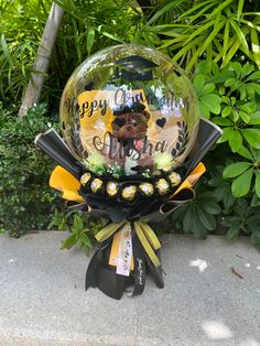 there is a glass ball that says happy birthday on it and some ribbons around it