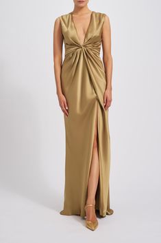 a woman wearing a gold dress with a slit