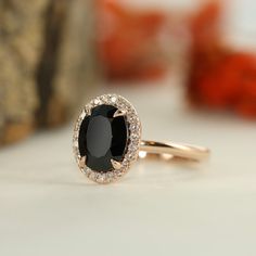 an oval black and white diamond ring sits on a table