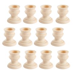 twelve white wooden candlesticks on a white background