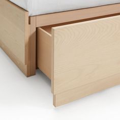 a close up of a bed with a wooden headboard and foot board on it