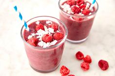 two glasses filled with raspberry smoothie and garnished with coconut flakes