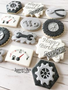 decorated cookies in the shape of different types of motorbikes and gauges are arranged on a white wooden surface