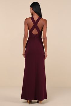 the back of a woman wearing a long dress with cutouts on it and a deep purple