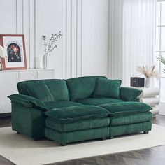 a large green couch sitting on top of a white rug