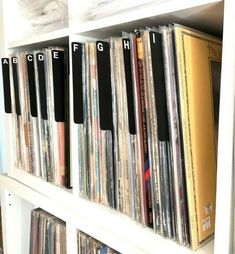 a white shelf filled with lots of records