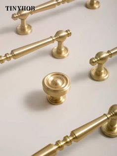 an assortment of golden handles and knobs on a white surface with the words tinyjop above them