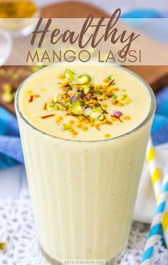 a smoothie in a glass with nuts on top and text overlay that reads healthy mango lass