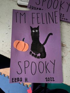 a purple sign with a black cat and pumpkin on it that says i'm feline spooky