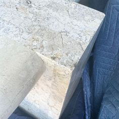 a close up of a marble block on a blue chair with a quilted back