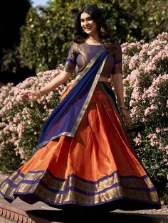 Embrace the vibrant elegance of our orange Kanchipuram silk lehenga, exquisitely paired with a blue Kanchipuram silk choli and a matching blue georgette dupatta. This ensemble showcases the rich heritage and craftsmanship of traditional Indian attire, featuring intricate zari weaving work that exudes luxury and sophistication. The orange lehenga, with its striking color and detailed design, is the perfect choice for making a bold statement at any grand event.
The lehenga offers a generous 3.70-m Kanchipuram Half Saree, South Indian Lehenga, Ceremonial Wedding, Silk Half Saree, South Indian Wedding Saree, Orange Lehenga, Stylish Kurtis Design, Simple Lehenga, Half Saree Lehenga