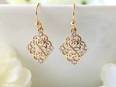 These lovely filigree earrings, have a beautiful 24k champagne gold finish. Tiny, clear zircon gemstones, embellish the ornate design. They are lightweight, making them comfortable to wear. Product details: - 18k gold plated ear wires; Lead and nickel free - 24k champagne gold filigree charm with clear zircon gemstones - Handmade, with lots of love and care! * Length:      .9 inches * Width:       .5 inches ❤ You can click here to see more unique jewelry from Flutterbird: https://www.etsy.com/shop/FlutterbirdCo My goal is to provide every customer with exceptional service. Please message me if you have any questions. Thank you for supporting my small business!  Please visit my F.A.Q. and shop policy sections for additional info. Elegant Yellow Gold Chandelier Earrings With Diamond Accents, Exquisite Diamond Chandelier Earrings In Gold, Elegant Gold Diamond Earrings In 14k Gold, Elegant Yellow Gold Chandelier Earrings With Cubic Zirconia, Elegant Yellow Gold Crystal Earrings For Anniversary, Elegant Gold Diamond Earrings With Accents, Gold Chandelier Earrings With Diamond Accents, Gold Drop Diamond Earrings For Gift, Delicate Gold Earrings For Anniversary