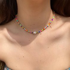 Multicolored beaded choker, the perfect accessory for anyone who loves to add a pop of color to their outfit! Handcrafted with love , this choker features a delicate beaded design that showcases a beautiful array of hues. Shades of pink, purple, blue, green, orange, red, and yellow that blend seamlessly together. A single pearl accent in the center adds a touch of elegance and sophistication to the overall design. This choker is also incredibly comfortable to wear, with a soft and lightweight construction that won't weigh you down. Whether you're dressing up for a special occasion or adding a colorful touch to your everyday look, this beaded choker is sure to turn heads and make a statement. The perfect addition to any jewelry collection, this choker is a must-have for anyone who loves bol Colorful Beaded Necklaces With Letter Beads, Trendy Multicolor Letter Beads Choker, Colorful Letter Beads Necklace, Multicolor Beaded Chain Choker, Festival Letter Beads Choker Necklace, Multicolor Tiny Beads Choker For The Beach, Multicolor Beaded Choker For Summer, Beaded Letter Beads Choker Necklace, Summer Multicolor Beaded Choker