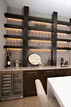 a kitchen with wine glasses on the shelves