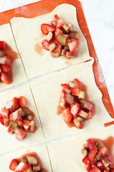 sliced strawberries and other fruit on top of dough