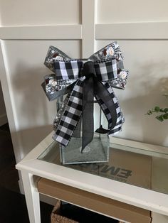 a box with a black and white bow on it sitting on top of a table